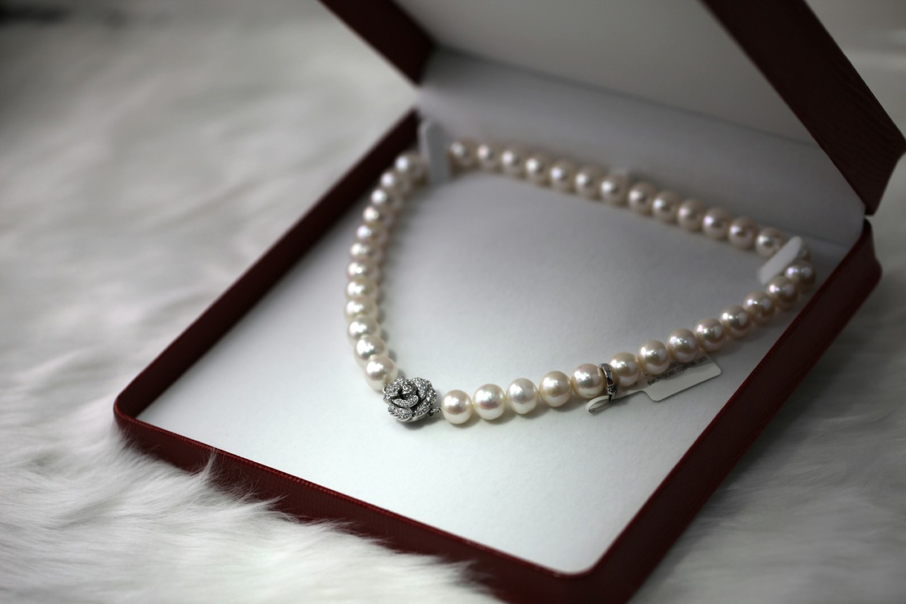A pearl necklace resting in an open box