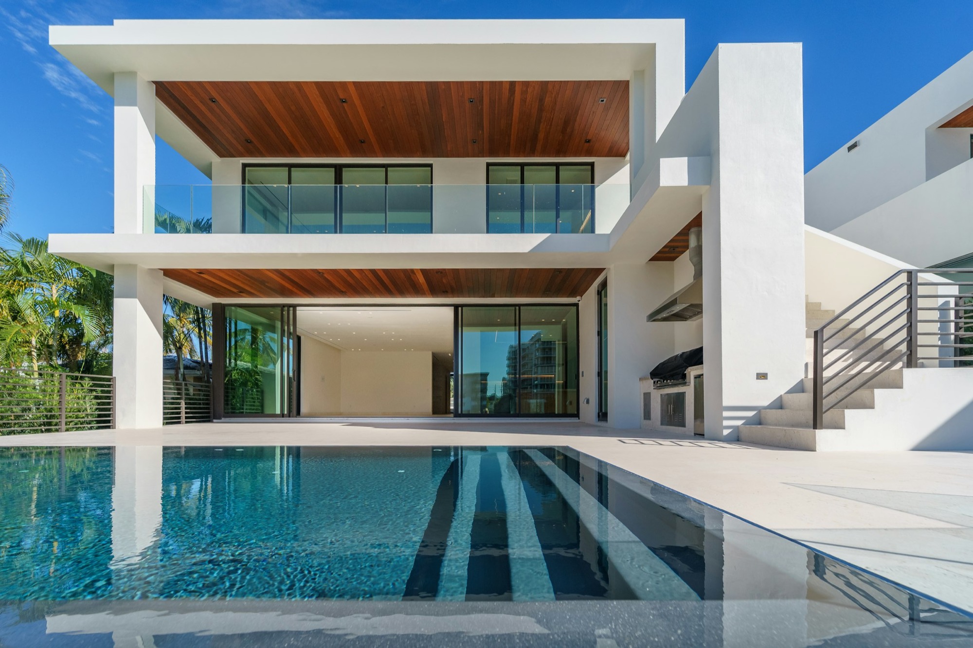 A modern house with a still pool in hard daylight